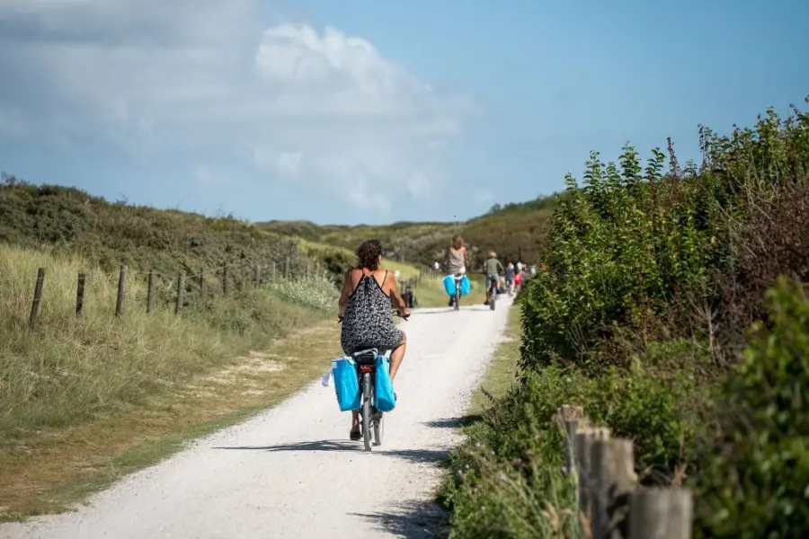 Vrouw fietsen door duinen Ameland